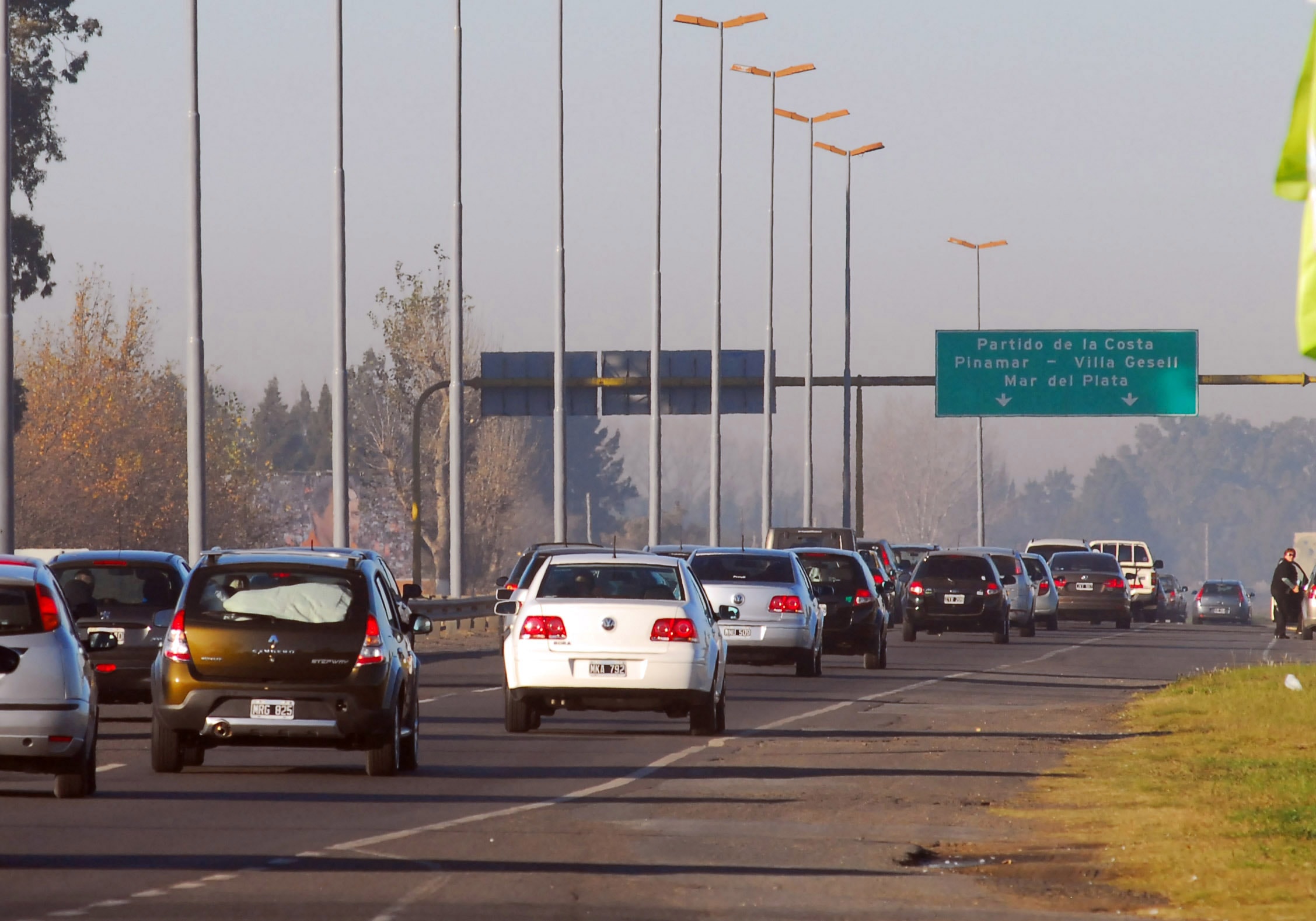 Autos circulando en los dos carriles de la Autovía 2, con un cartel verde que indica Partido de la Costa, Pinamar, Villa Gesell y Mar del Plata