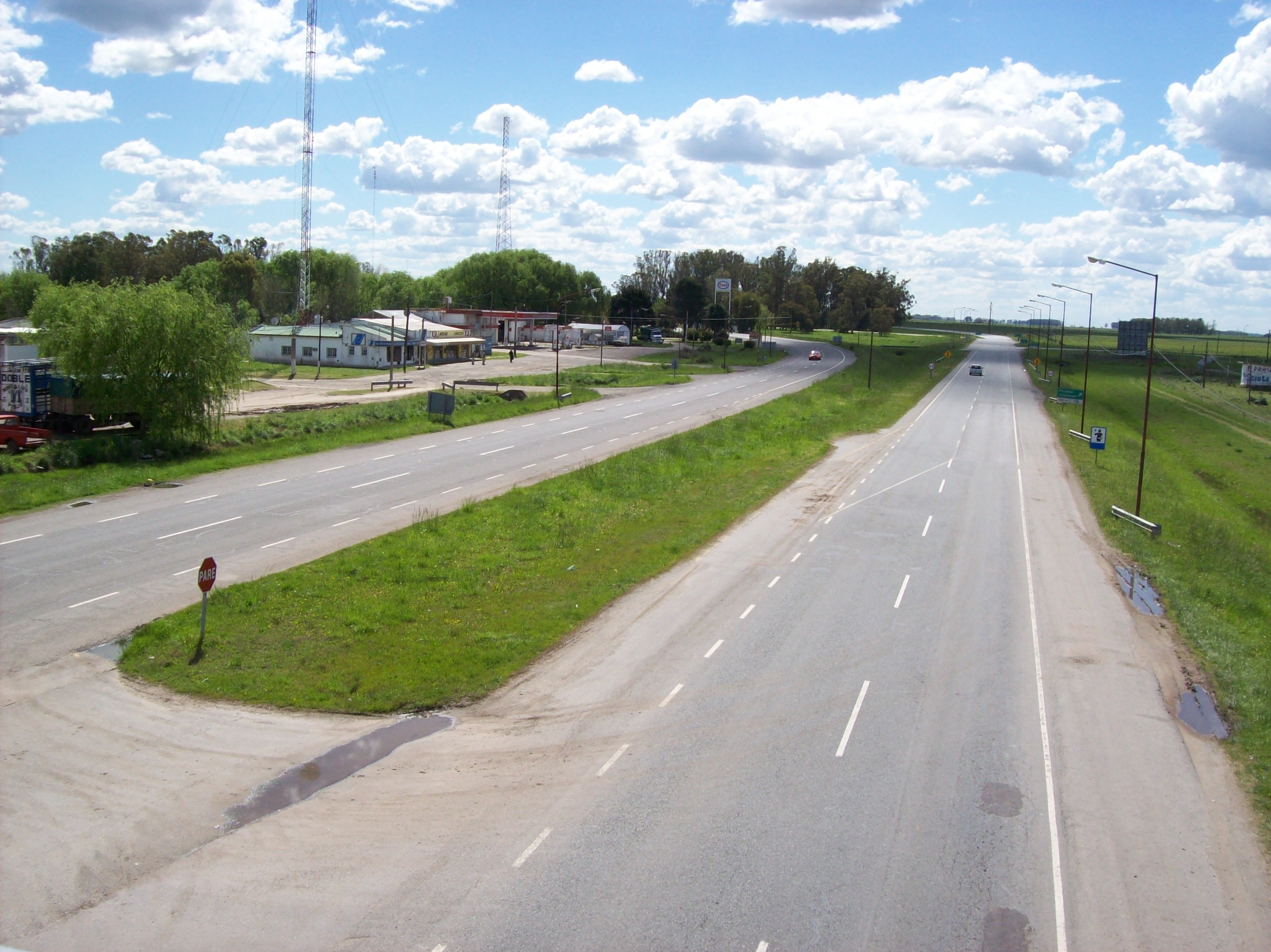 Las dos calzadas de la Autovía 2 a su paso por Las Armas, con una estación de servicio y construcciones al costado del camino
